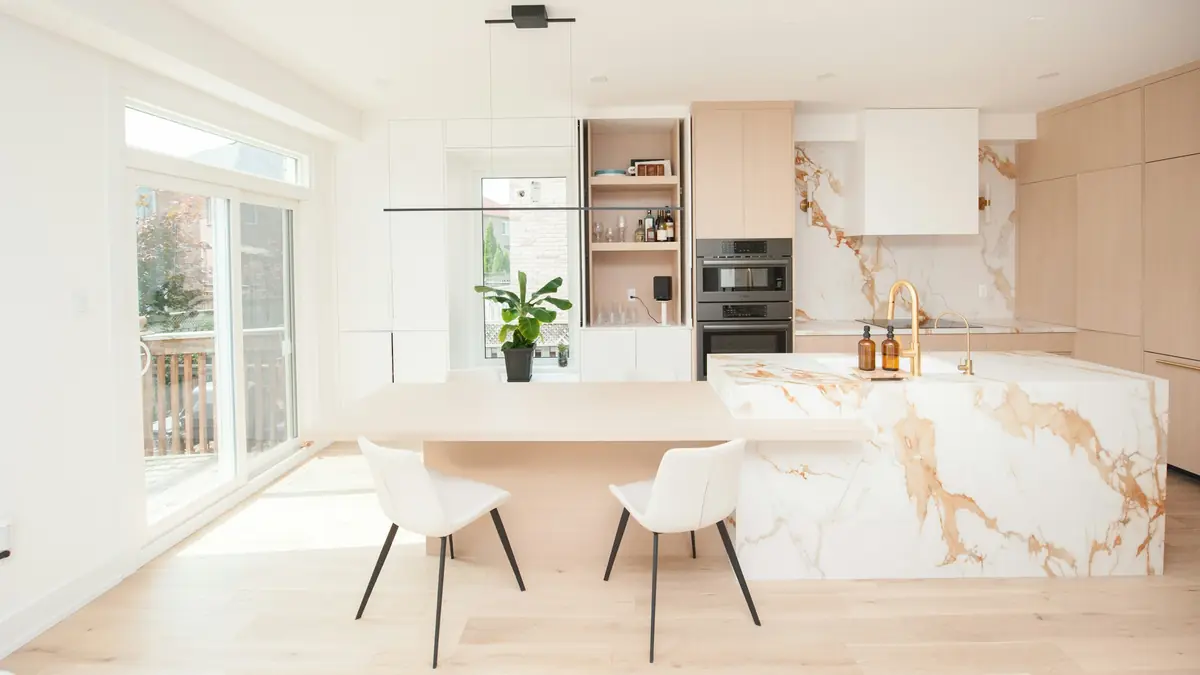 A freshly renovated white kitchen with a marble island